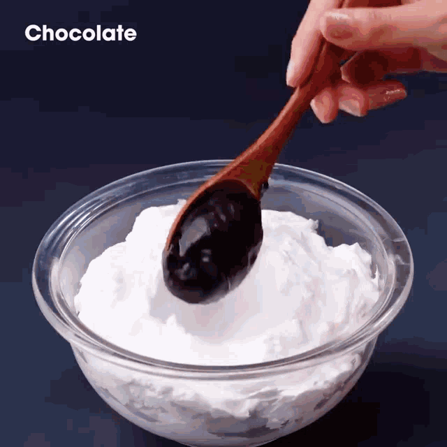 a bowl of whipped cream with a wooden spoon in it and the word chocolate on the bottom