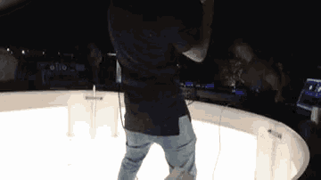 a man is standing on a stage holding a microphone and dancing .