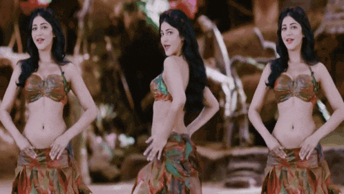 a woman in a bikini is dancing in front of a crowd