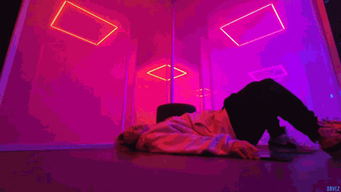 a person is laying on the floor in a room with purple and blue lights behind them and the word dovez at the bottom