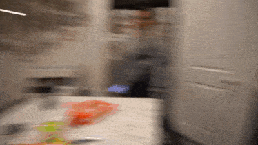 a blurred image of a person standing in a kitchen