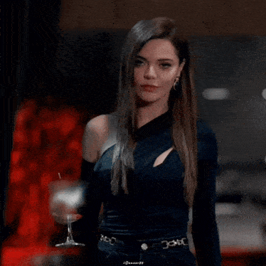 a woman in a black dress is holding a glass of wine with a belt that says ' dolcegabb ' on it