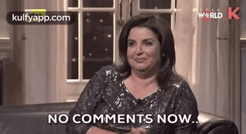 a woman in a sequined dress is sitting on a couch and says `` no comments now '' .