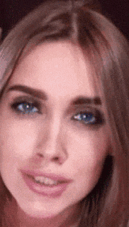 a close up of a woman 's face with a blue eye