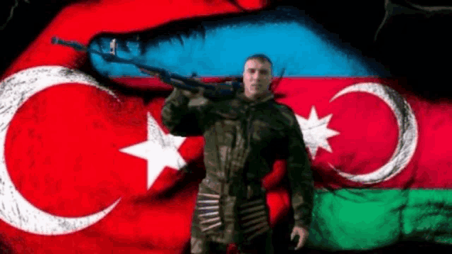 a soldier is holding a gun in front of a flag of azerbaijan .