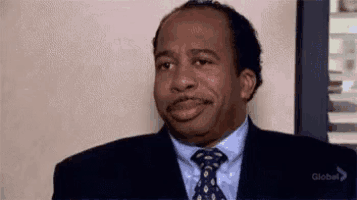 a man in a suit and tie is looking at the camera .