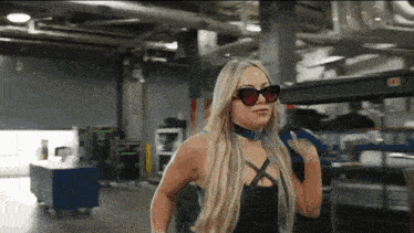 a woman wearing sunglasses and a choker stands in a room