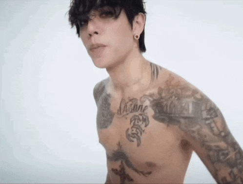 a shirtless man with a tattoo on his chest says insane