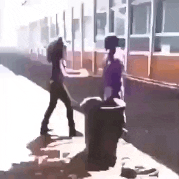 a woman is standing next to a trash can on a sidewalk .