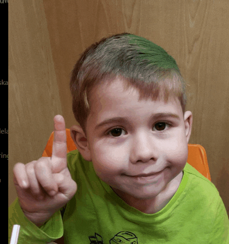 a young boy with green hair is giving a thumbs up sign