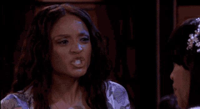 a woman with a surprised look on her face wearing a white top