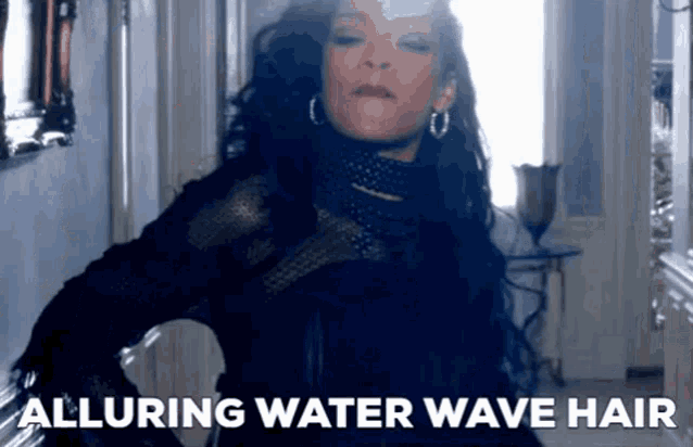 a woman in a black dress is standing in a hallway with the words alluring water wave hair below her .