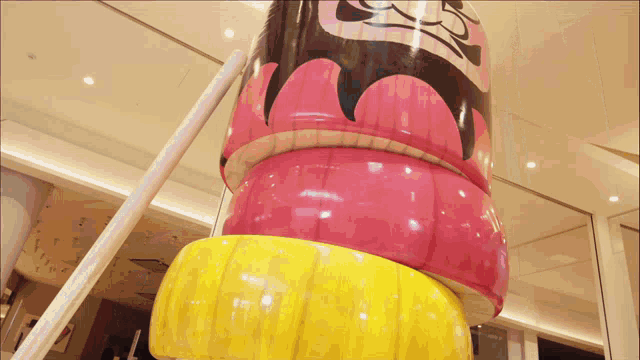 a stack of pink and yellow objects with a face on them