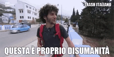 a man with curly hair and a backpack is walking down a street with a caption that says trash italiano .
