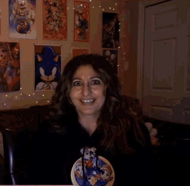 a woman wearing a sonic the hedgehog t-shirt is smiling