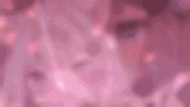 a girl with a bow on her head is smiling in a pink background with chinese writing