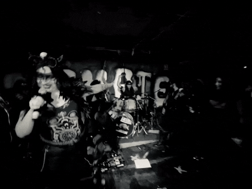 a black and white photo of a band playing in front of a wall that says nightmare on it