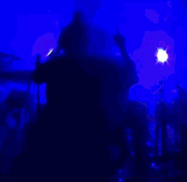 a silhouette of a person in a dark room with purple lights
