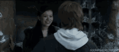 a man and a woman are standing next to each other in a dark room
