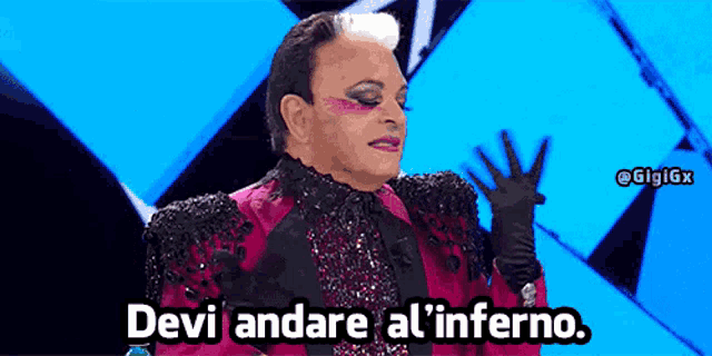 a man in a pink suit and black gloves says devi andare al l' inferno