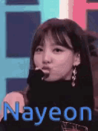 a close up of a woman making a funny face with the name nayeon written in blue .