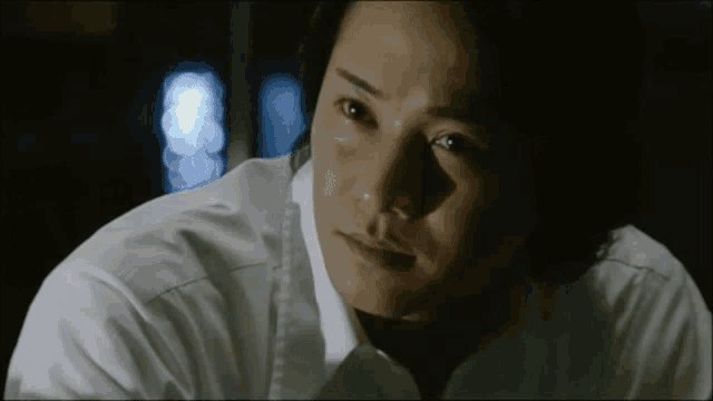 a man in a white shirt is looking at something
