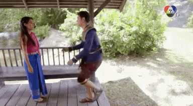 a man and a woman are standing next to each other on a porch .