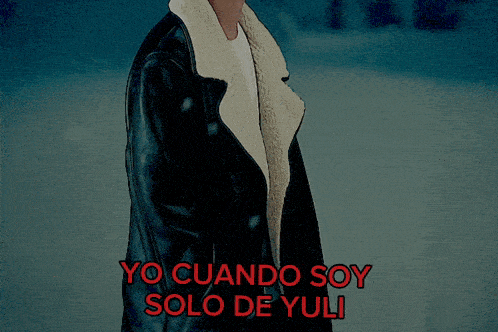 a man in a black coat is standing in the snow with yo cuando soy solo de yuli written in red