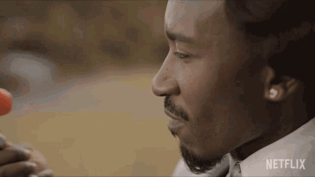 a close up of a man 's face with a netflix logo on the bottom