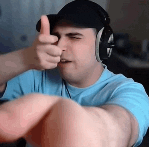 a man wearing headphones is giving a thumbs up sign