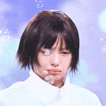 a woman with short hair is wearing a white jacket and a microphone in her mouth