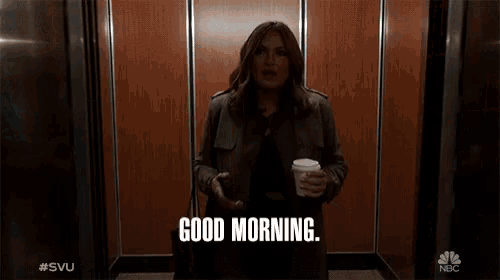 a man and a woman are standing in front of an elevator and the woman is saying is it