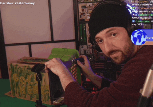 a man wearing headphones stands in front of a green box that says bscriber on the bottom