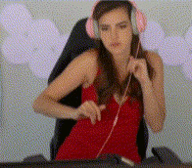 a woman wearing headphones is sitting in front of a computer monitor