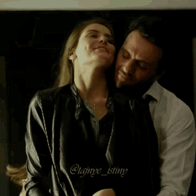 a man is kissing a woman on the cheek while hugging her .