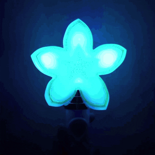 a blue light in the shape of a flower is lit up in the dark