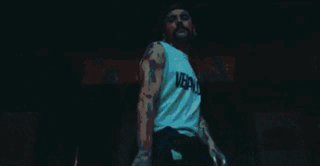 a man is standing on a stage wearing a green shirt that says vegan di .
