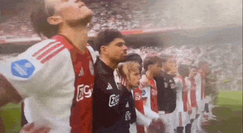 a group of soccer players are standing in a row on a soccer field .