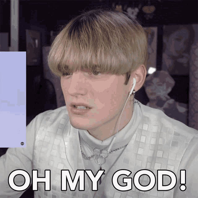 a man wearing ear buds and a white shirt says oh my god