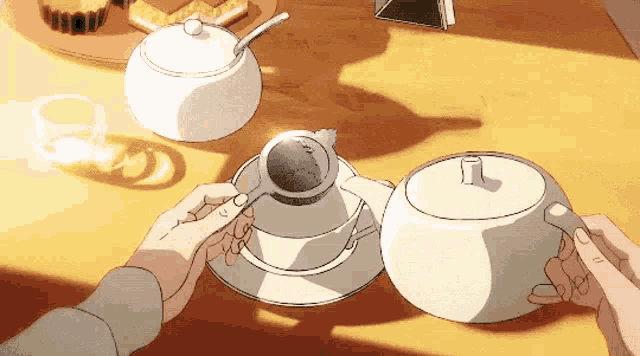 a person is pouring tea into a cup from a teapot .