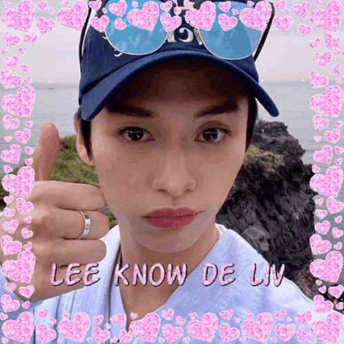 a man wearing a blue hat and sunglasses giving a thumbs up with the words lee know de liv written on the bottom