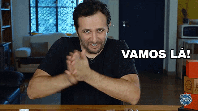 a man in a black shirt is clapping with the words " vamos la " behind him
