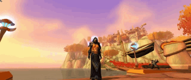 a person in a hooded robe stands in front of a sunset