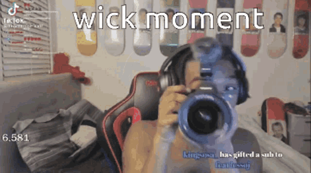 a man wearing headphones is taking a picture with a camera with the words wick moment above him
