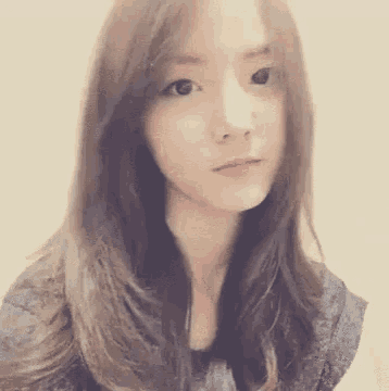 a woman with long hair is looking at the camera .