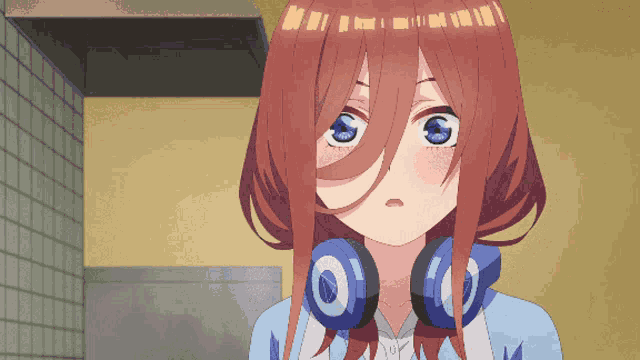 a girl with headphones around her neck is looking at something