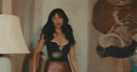 a woman is standing in a room next to a lamp .