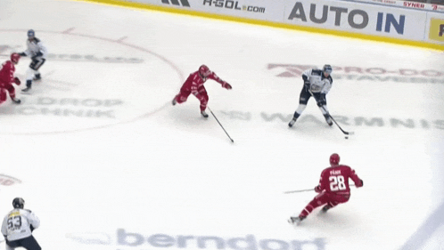a hockey game is being played in front of a banner that says auto in
