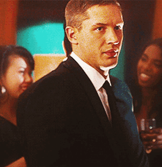 a man in a suit and tie is standing in a crowd