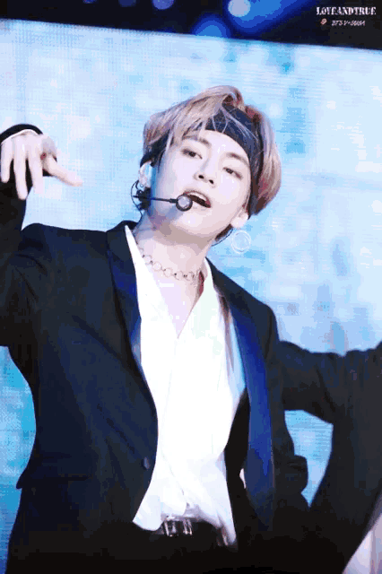 a man wearing a headband and a microphone with love and tree written on the bottom right